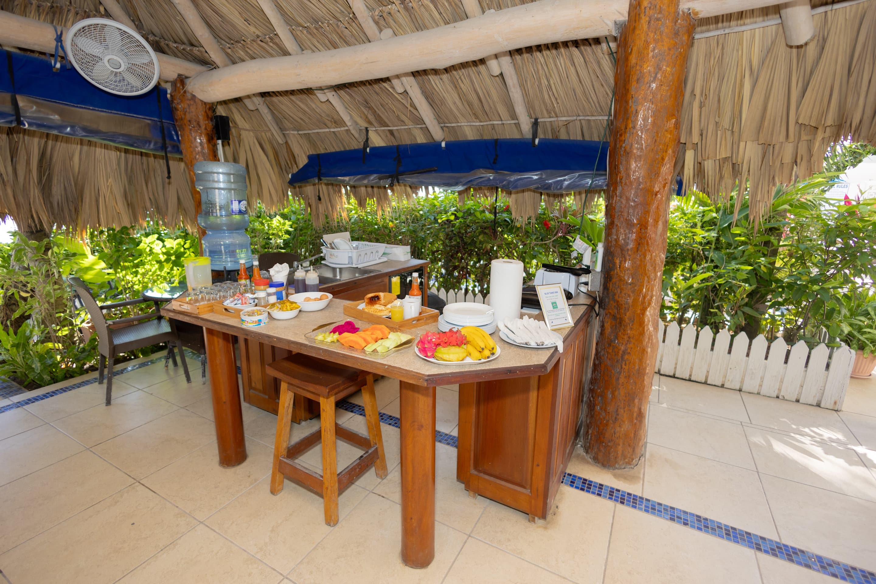 Welcome to Suite #5 at Blue Tang Inn as you enter the dining area with green futon, full kitchen, ki