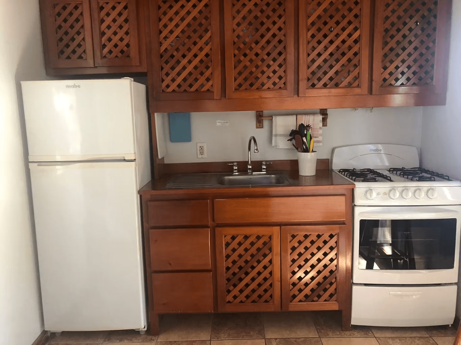 Kitchen with beautifully finished hardwood cabinets, refrigerator, sink, and stove