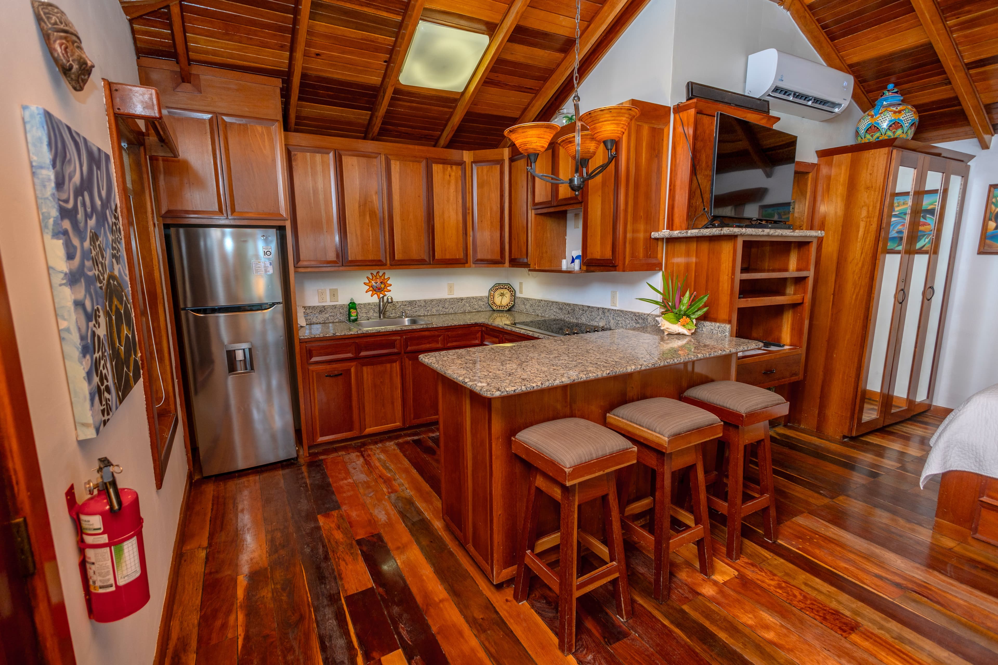 Kitchen and dining table with refrigerator, stove and oven, microwave, sink, coffee maker, blender,