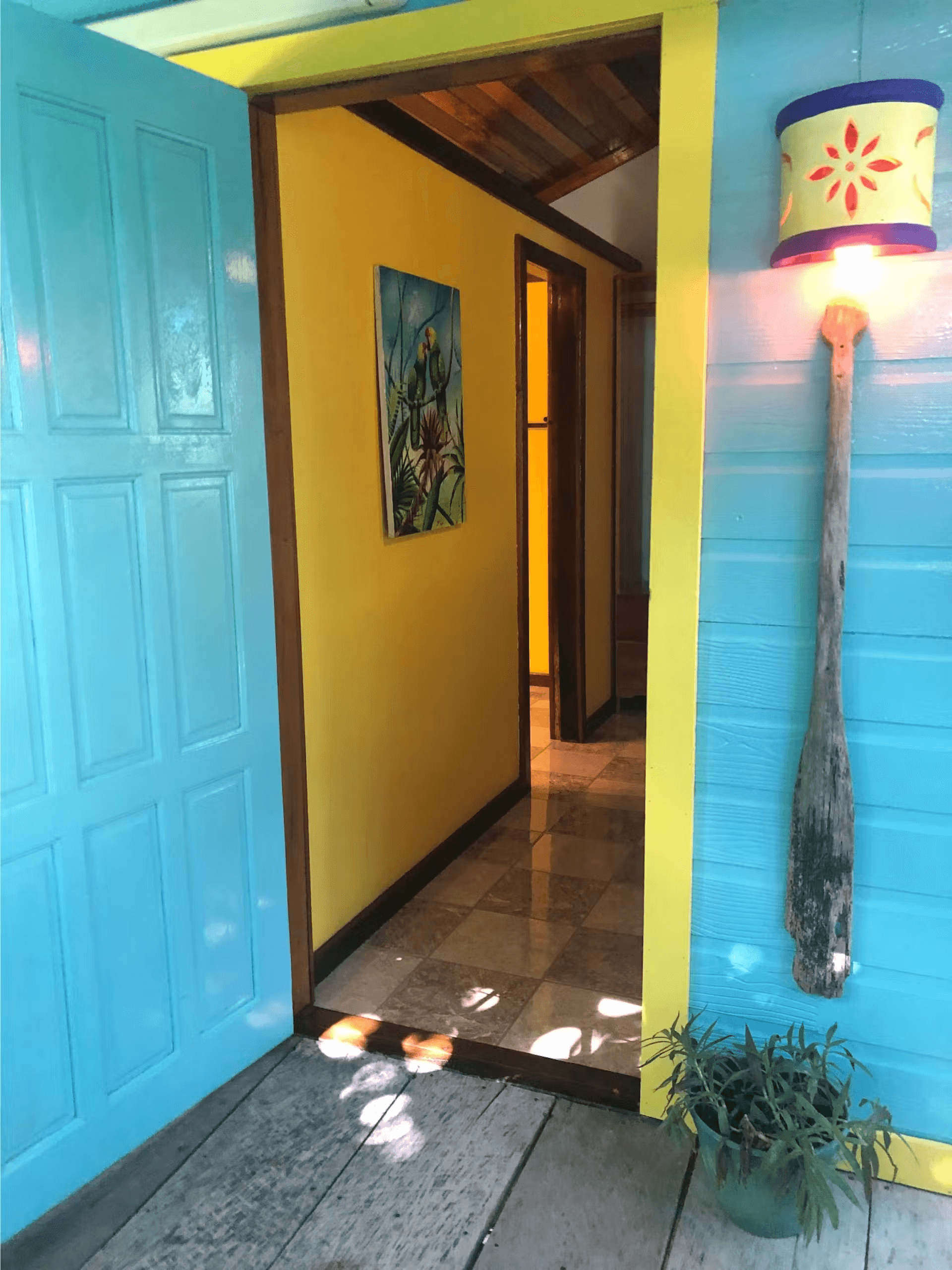 Bright blue front door leading into living area of cabana, the right side of the doorway is adorned