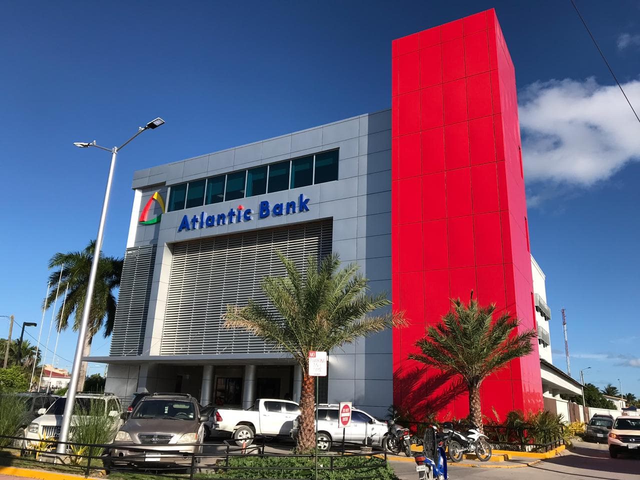 The image shows a modern building with a bright red section and the sign for Atlantic Bank.