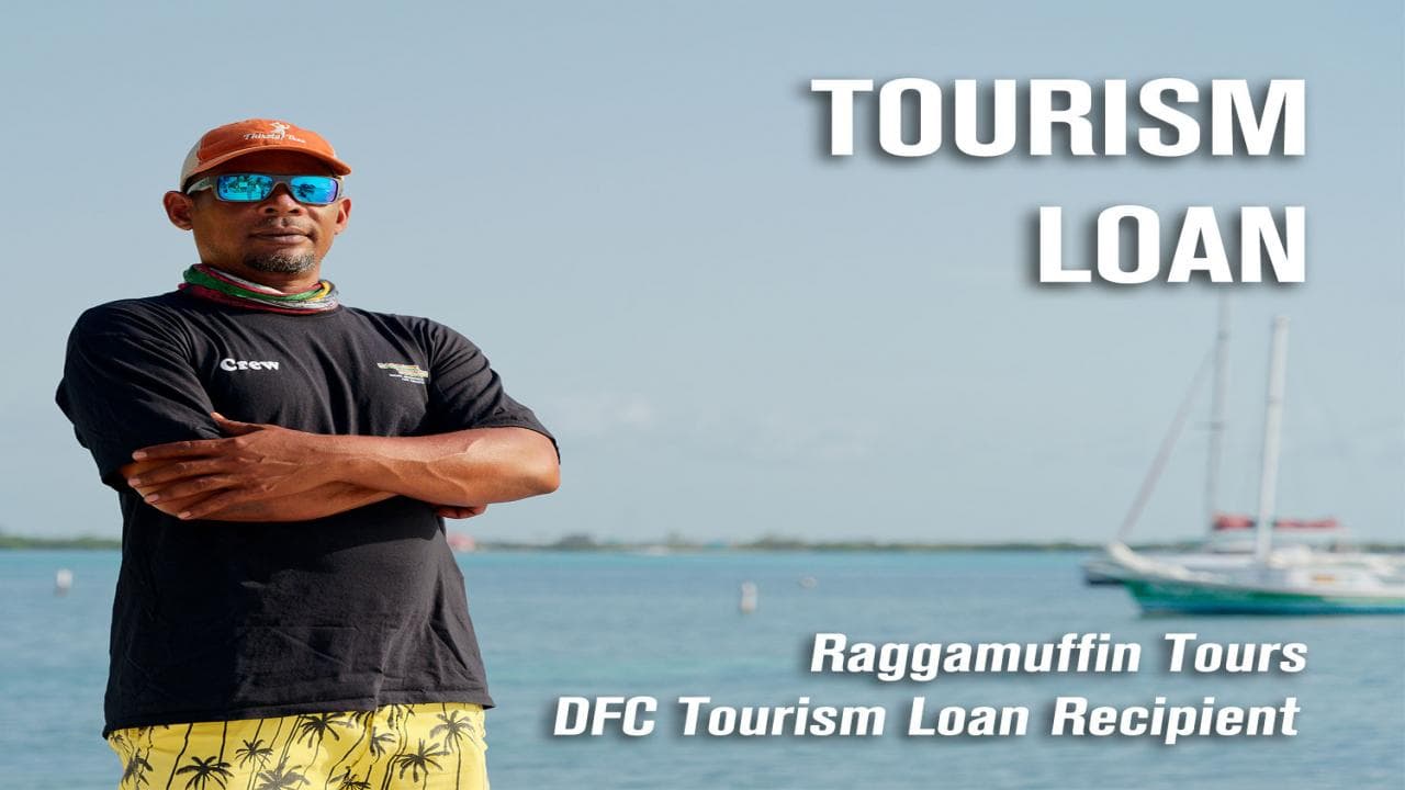 A man stands by the water, representing Raggamuffin Tours as a recipient of a tourism loan.