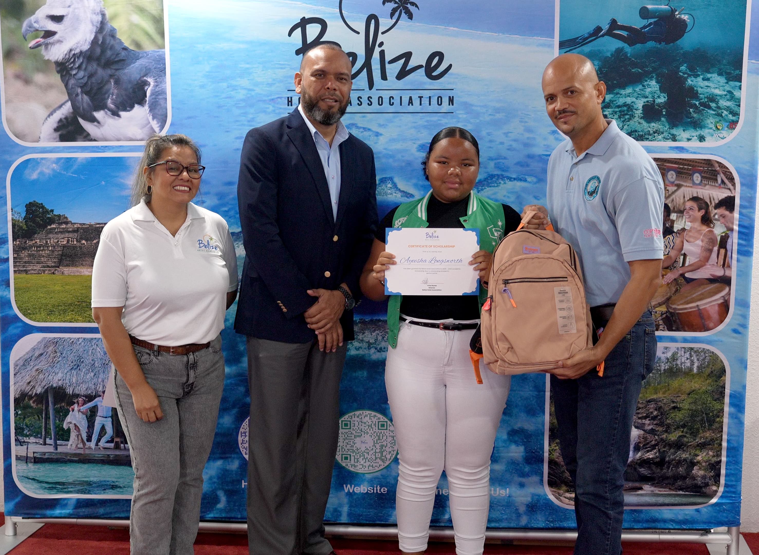 Four individuals stand in front of a backdrop, with a scholarship winner holding a certificate and a backpack.