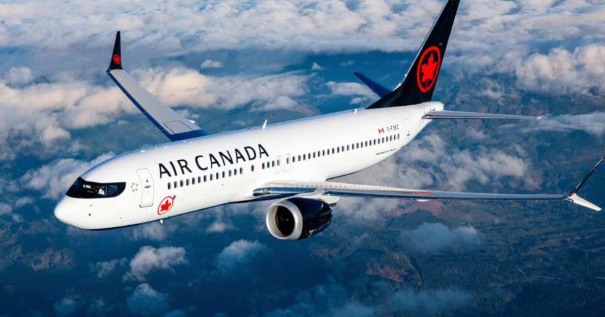 An Air Canada airplane flying above fluffy clouds. An Air Canada airplane flying above fluffy clouds.