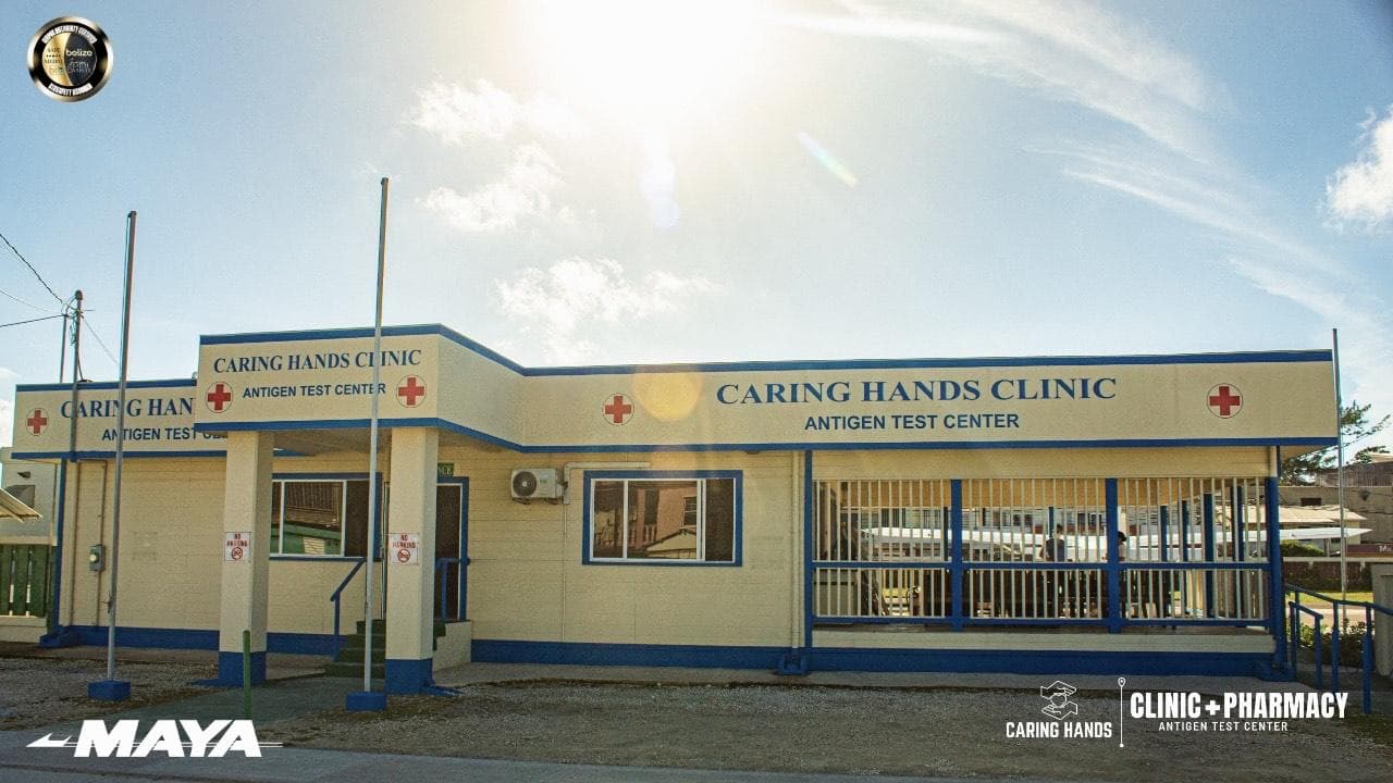 Exterior view of the Caring Hands Clinic, an antigen test center, featuring a blue and yellow building with a pharmacy sign.