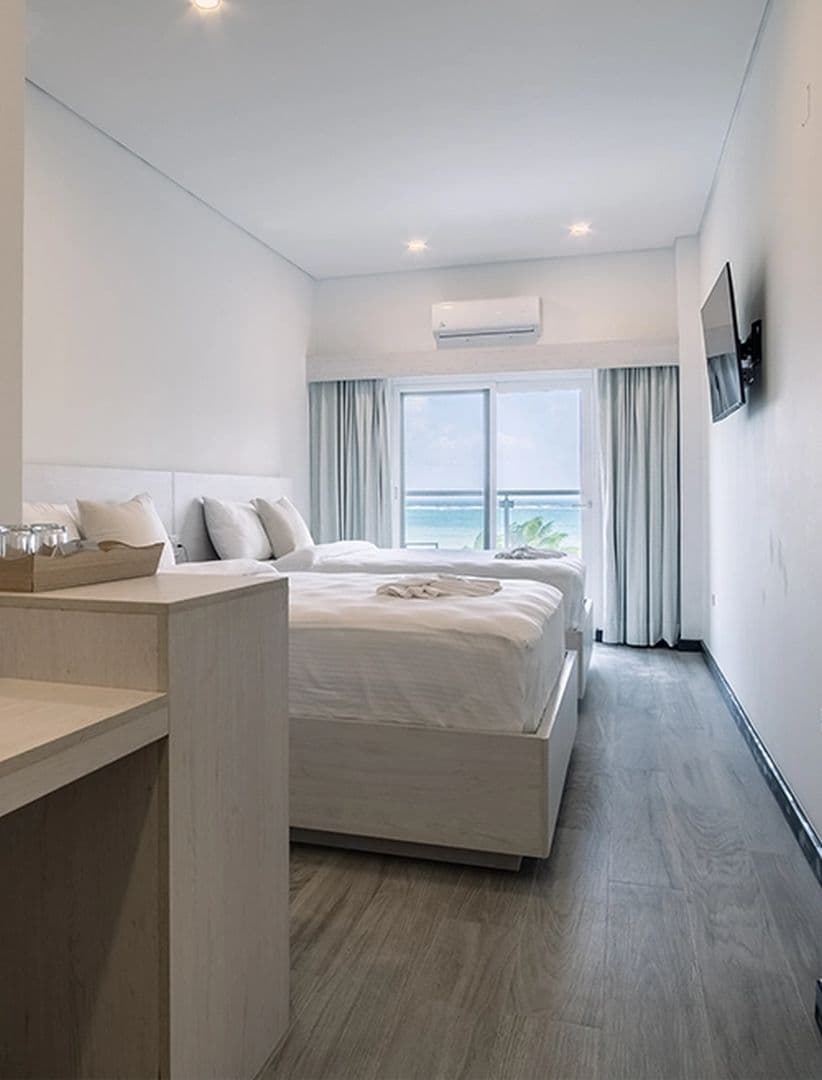 Room view with bed, tv, and balcony view